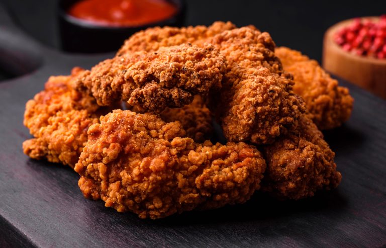 Crispy spicy fried chicken with golden seasoned coating on a plate